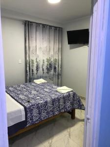 a bedroom with a bed with a blue and white blanket at Áncora Beach Hotel in Máncora
