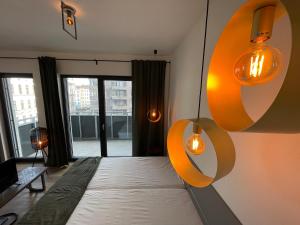 a bedroom with a bed and lights on the wall at Theatre Brno Apartments in Brno