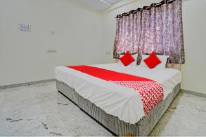 a bedroom with a large bed with red pillows at OYO Flagship BlueBird Service Apartment in Nagpur