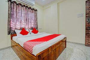 Un dormitorio con una cama grande con almohadas rojas. en Hotel O BlueBird Service Apartment, en Nagpur 21 fotos más