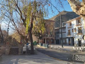 a city street with a tree and tables and chairs at Casa Altuna in Pinos Genil