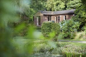 a small wooden house in the middle of a garden at Y Caban at Wig Farm near Llangrannog in Llandysul