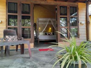 een kamer met een veranda met een bed en een schommel bij Golden Beach Chalets in Arugam Bay