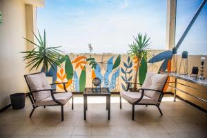 2 sillas y una mesa en un balcón con un mural en LC Hoteles Piura, en Piura