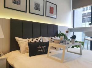 a bedroom with a bed with a black headboard and a table at Infinity Pool Scarletz Suites KLCC in Kuala Lumpur