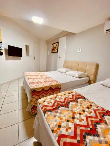 um quarto de hotel com duas camas e uma televisão em Hotel Porto Salvador em Salvador