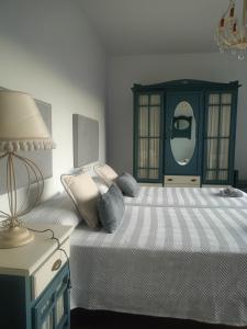 a bedroom with a bed with a lamp and a dresser at Villa Cultural MONTELUCÍA in Montecorto +63 photos