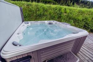 eine Whirlpool-Badewanne auf einer Terrasse in der Unterkunft Woody Park in Sankt Georgen ob Murau