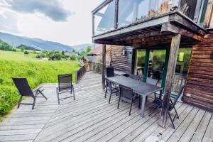 a wooden deck with a table and chairs on it at Woody Park in Sankt Georgen ob Murau