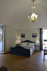 a bedroom with a large bed and a chandelier at Terrazza Campailla in Modica