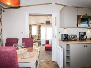 a kitchen and living room with a table and chairs at Chichester Lakeside Holiday Park in Chichester