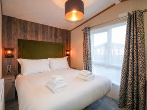 a bedroom with a large bed with towels on it at Chichester Lakeside Holiday Park in Chichester