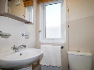 a bathroom with a sink and a toilet and a window at Chichester Lakeside Holiday Park in Chichester +20 photos