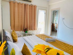 a bedroom with two beds with yellow pillows at KP Suites Gachibowli in Hyderabad