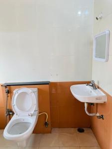 a bathroom with a toilet and a sink at KP Suites Gachibowli in Hyderabad