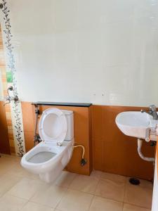 La salle de bains est pourvue de toilettes et d'un lavabo. dans l'établissement KP Suites Gachibowli, à Hyderabad