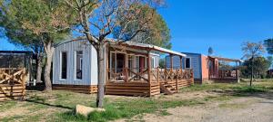 Cabaña pequeña con porche junto a un árbol en Camping RCN Domaine de la Noguière, en Le Muy