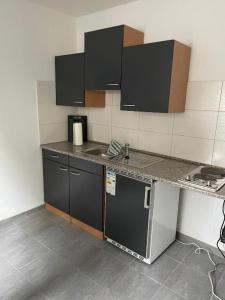 a kitchen with black cabinets and a counter top at Fahrer- und Logistikservice in Hecklingen