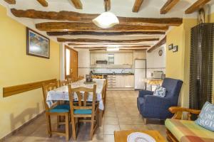 cocina y sala de estar con mesa y sillas en Casa TEULÉ en Les Iglésies