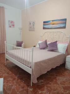 サン・ヴィート・ロ・カーポにあるCasa Blancaの白いベッド(紫色の枕付)が備わるベッドルームです。