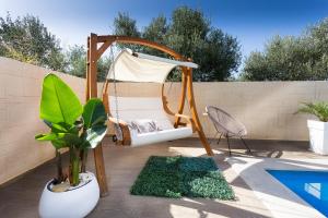 a patio with a hammock and a swing and plants at Villa Elisabeth View in Platanias