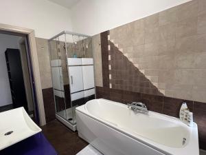 un baño con bañera y ducha de cristal en Appartamento Maya Torino, en Turín