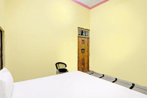 a bedroom with two beds and a wooden shelf at OYO J.M.D Restaurant &rooms in Jhājhar