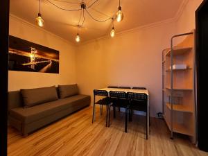 a living room with a couch and a table and chairs at Apartament 70’s in Kołobrzeg