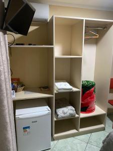 a closet with a tv in a room at Hotel Jovilá in Jaraguá do Sul