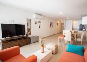 sala de estar con TV de pantalla plana y sofá en Acogedor Apartamento Marbella ideal familias en Cartagena de Indias