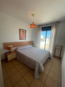 - une chambre avec un lit et une grande fenêtre dans l'établissement Alpen 1 Font Nova Tierra de Irta, à Peñíscola