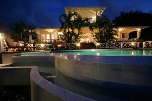 a swimming pool in front of a house at night at Beautiful 3 BR Villa in Cap Estate in Cap Estate