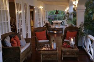 weranda z wiklinowymi krzesłami i stołem ze świecami w obiekcie Beautiful 3 BR Villa in Cap Estate w mieście Cap Estate
