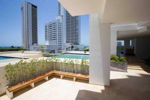 - Balcón con banco y piscina en un edificio en Acogedor Apartamento Marbella ideal familias, en Cartagena de Indias