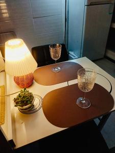 two tables with wine glasses and a lamp on them at With us house in Ansan