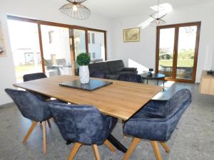 einen Esstisch mit blauen Stühlen und einem Sofa in der Unterkunft Villa Nova Resort in Sveti Peter