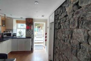 a stone wall in a kitchen with a stone wall at Cosy Cottage in Garnant in Garnant