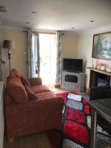 a living room with a couch and a television at Cosy Cottage in Garnant in Garnant