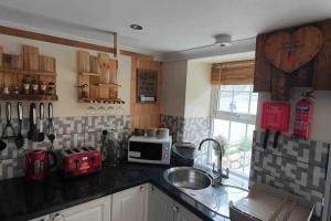 a kitchen with a sink and a counter top at Cosy Cottage in Garnant in Garnant