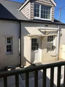 a white house with a window and a balcony at Cosy Cottage in Garnant in Garnant