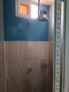 a bathroom with a shower with a blue wall at Casa Chikuwa in San Juan La Laguna