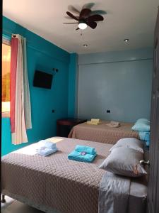 1 dormitorio con 2 camas y ventilador de techo en Casa Chikuwa, en San Juan La Laguna