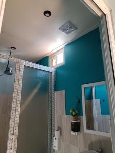 a bathroom with a shower and a blue wall at Casa Chikuwa in San Juan La Laguna