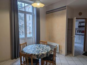 comedor con mesa, sillas y ventana en Gîte Bourbonne-les-Bains, 2 pièces, 2 personnes - FR-1-611-99, en Bourbonne-les-Bains