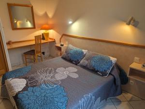 1 dormitorio con cama, espejo y escritorio en Gîte Bourbonne-les-Bains, 2 pièces, 2 personnes - FR-1-611-99, en Bourbonne-les-Bains