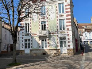 un edificio con un árbol delante de él en Gîte Bourbonne-les-Bains, 2 pièces, 2 personnes - FR-1-611-99, en Bourbonne-les-Bains