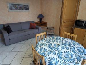 波旁莱班Luxueux Gîte 3* avec Terrasse Plein Sud, à 100m des Thermes et Centre-ville - FR-1-611-100的客厅里有一张桌子和一张沙发