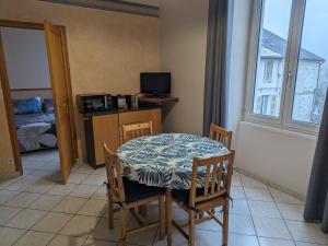 ein Esszimmer mit einem Tisch, Stühlen und einem Fenster in der Unterkunft Gîte Bourbonne-les-Bains, 2 pièces, 2 personnes - FR-1-611-100 in Bourbonne-les-Bains