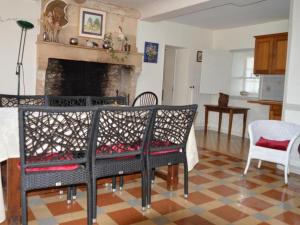 ein Wohnzimmer mit einem Kamin, einem Tisch und Stühlen in der Unterkunft Gîte Ri, 4 pièces, 6 personnes - FR-1-497-193 in Ri