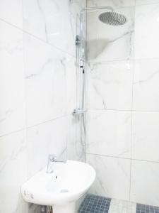 ein weißes Bad mit einem Waschbecken und einer Dusche in der Unterkunft Goodmayes Park Home in Goodmayes